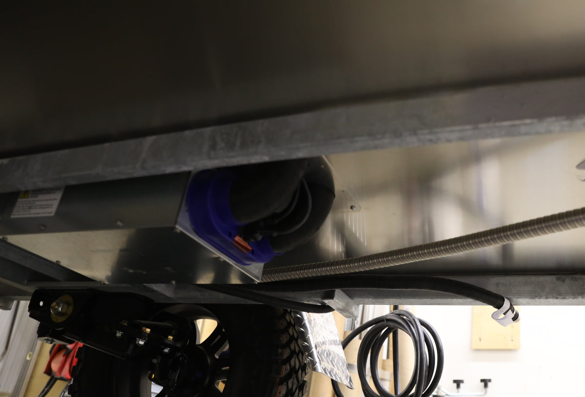Close-up underside view of a trailer with a heater installed