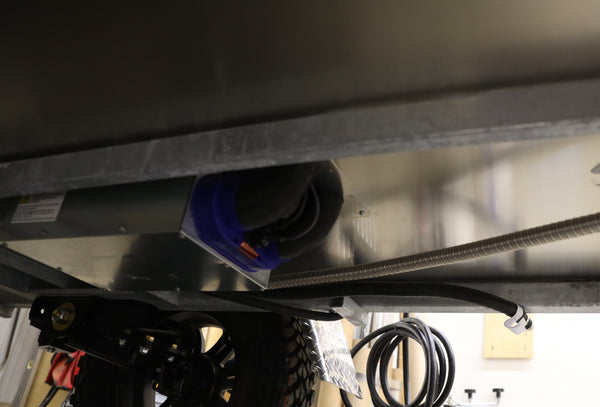 Close-up underside view of a trailer with a heater installed